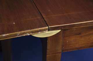 There are four brass fasteners that slip into notches on the table 