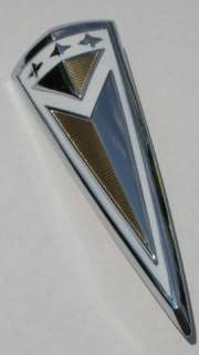This is a new reproduction emblem. White and gold on chrome. Measures 
