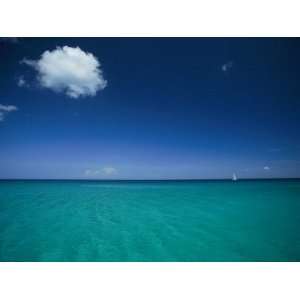  A Sailboat Plies a Clear Blue Sea under Sky with a Single 