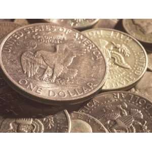Close up of Shiny American Silver Dollar Coin on a Pile of Other Coins 